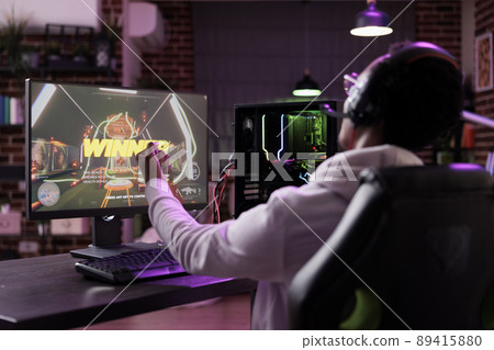 Happy player celebrating video games championship win, streaming online gaming tournament. Cheerful adult winning action rpg gameplay competition on computer, having fun on stream. Happy player celebrating video games championship win, streaming online gaming tournament. Cheerful adult winning action rpg gameplay competition on computer, having fun on stream. 89415880
