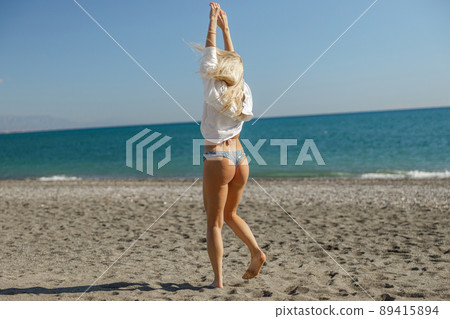 Rear view of fit woman enjoying summer vacation near the sea 89415894