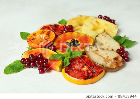 Concept of tasty food with grilled fruits on white textured background. Concept of tasty food with grilled fruits on white textured background. 89415944
