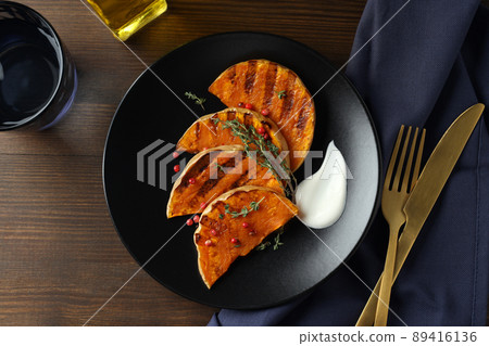 Concept of tasty eating with baked pumpkin on wooden background 89416136