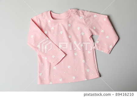 Pink female baby clothes on light gray background 89416210