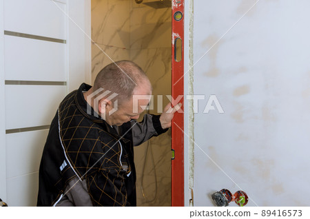 Interior wood door installation working with level Interior wood door installation working with level 89416573