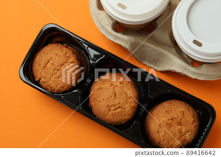 Cookies and paper cups of coffee on orange background Cookies and paper cups of coffee on orange background 89416642