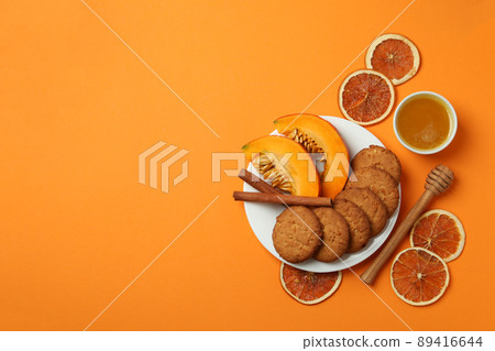 Concept of tasty food with pumpkin cookies on orange background Concept of tasty food with pumpkin cookies on orange background 89416644