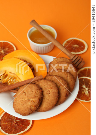 Concept of tasty food with pumpkin cookies on orange background Concept of tasty food with pumpkin cookies on orange background 89416645