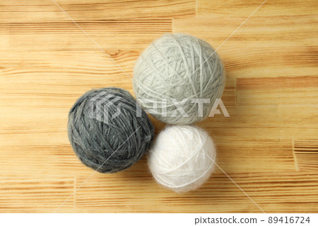 Multi colored balls of yarn on light wooden background Multi colored balls of yarn on light wooden background 89416724