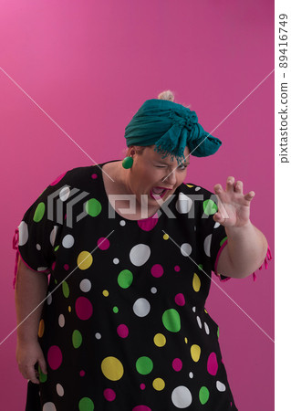 Plus size sexy model woman with trendy makeup, fashionable blonde in black short dress posing at the pink background in studio. 89416749