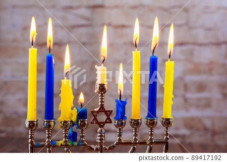 Menorah with candles for Hanukkah against defocused lights Menorah with candles for Hanukkah against defocused lights 89417192