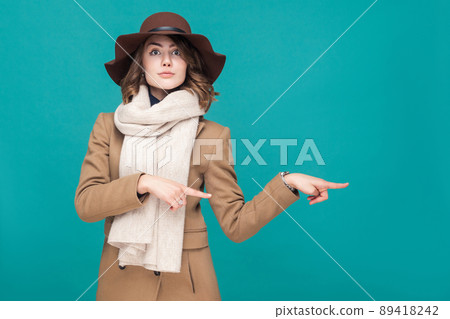 Happiness young adult woman pointing finger at copy space. Studio shot 89418242