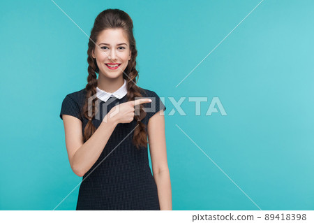 Business woman pointing finger right, at copy space. Studio shot, blue background Business woman pointing finger right, at copy space. Studio shot, blue background 89418398