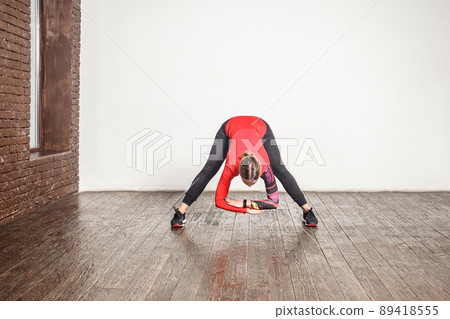 Sexy blonde woman standing in uttanasana pose. Studio shot Sexy blonde woman standing in uttanasana pose. Studio shot 89418555
