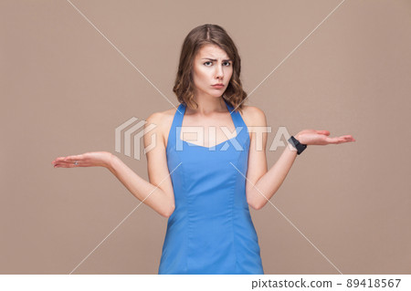 Choice concept. Confusion woman don't know what is better. Light brown background. Studio shot Choice concept. Confusion woman don't know what is better. Light brown background. Studio shot 89418567