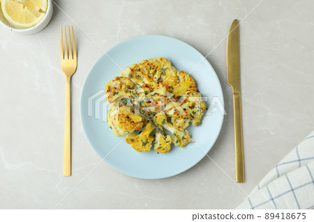 Concept of tasty eating with baked cauliflower on light textured background Concept of tasty eating with baked cauliflower on light textured background 89418675