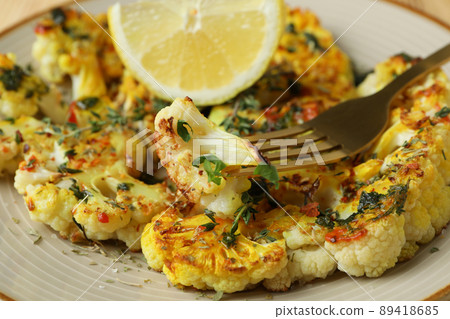 Concept of tasty food with baked cauliflower, close up Concept of tasty food with baked cauliflower, close up 89418685