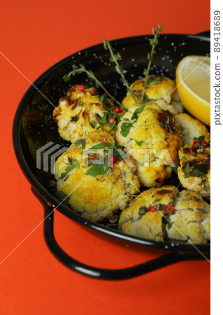 Bowl with baked cauliflower on orange background 89418689