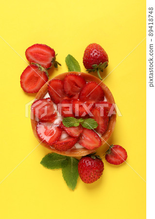 Delicious strawberry tart on yellow background, top view Delicious strawberry tart on yellow background, top view 89418748