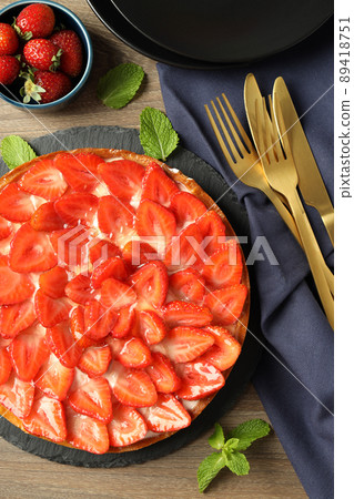 Concept of tasty food with strawberry tart on wooden table Concept of tasty food with strawberry tart on wooden table 89418751