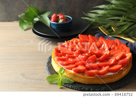 Concept of tasty food with strawberry tart on wooden table Concept of tasty food with strawberry tart on wooden table 89418752
