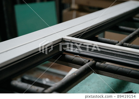 Production and manufacture of window profiles. Plastic and metal profiles close-up Production and manufacture of window profiles. Plastic and metal profiles close-up 89419154
