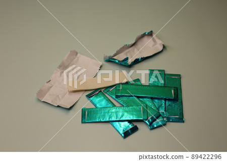 Mint sticks of gum are strewn across the table. Sweet chewing gum for cleaning the mouth from food. 89422296