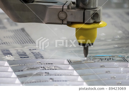 Close-up scene of multi-axis waterjet cutting machine cutting the aluminum plate. Close-up scene of multi-axis waterjet cutting machine cutting the aluminum plate. 89423069