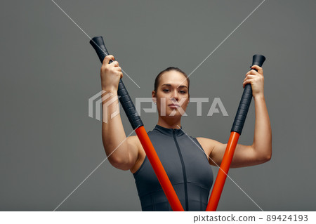 beautiful girl in sports uniform is training kung fu in the studio, fighter athlete, practicing martial arts with a stick 89424193