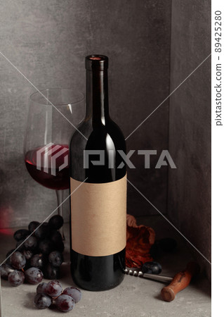 Bottle and glass of red wine with blue grapes. Bottle and glass of red wine with blue grapes. 89425280