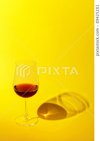 Glass of red wine on a yellow background. Glass of red wine on a yellow background. 89425281