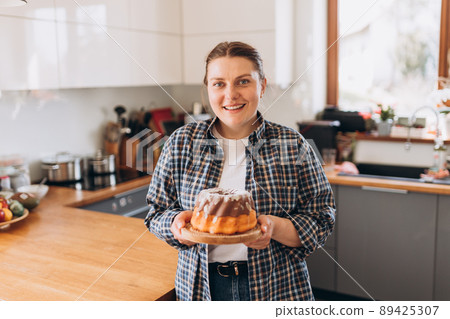 Young redhead woman pastry chef making chocolate cake in the kitchen. Baking Concept 89425307