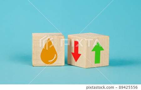 Wooden cube change UP arrow and Down arrow and oil symbol on blue background. Oil with arrow up 89425556