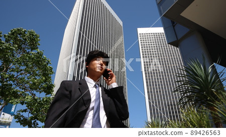 Japanese businessman calling while walking in downtown Los Angeles, USA 89426563