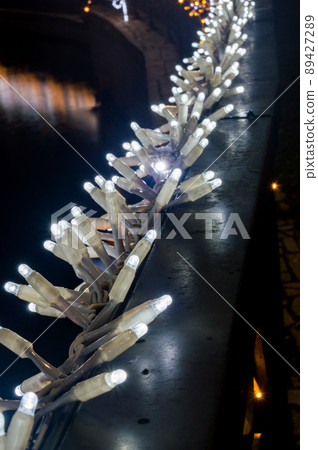 Hundreds of small lights on handrail in at night. 89427289