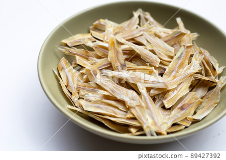 Dried anchovies in bowl on white background. 89427392