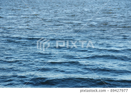 The raging waters of the river. Top view background texture of the raging elements. White foam on blue waving water The raging waters of the river. Top view background texture of the raging elements. White foam on blue waving water 89427977