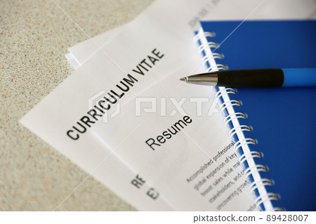 Top view of stack of office documents including resume and cv forms on the desk close to pen and notepad. Job seeking process. Hunting for workplace 89428007