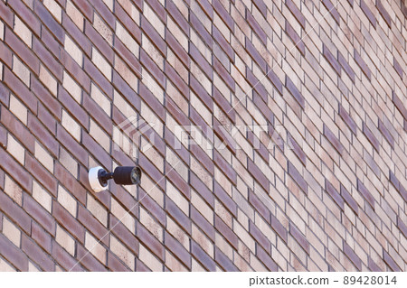 Black wireless CCTV security camera for area surveillance placed on brick wall. Surveillance cameras are modern technology to prevent thieves Black wireless CCTV security camera for area surveillance placed on brick wall. Surveillance cameras are modern technology to prevent thieves 89428014