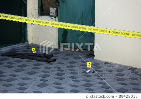 Crime scene tape for covering the area cordon. Yellow tape with blurred forensic law enforcement background in cinematic tone Crime scene tape for covering the area cordon. Yellow tape with blurred forensic law enforcement background in cinematic tone 89428015