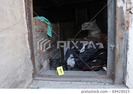 Evidence with yellow CSI marker for evidence numbering on the residental backyard in evening. Crime scene investigation concept Evidence with yellow CSI marker for evidence numbering on the residental backyard in evening. Crime scene investigation concept 89428025