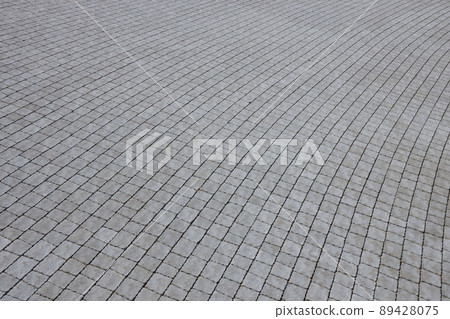 Gray color paving slabs in the pedestrian street sidewalk. Rough cobblestone pattern with many square shaped stones Gray color paving slabs in the pedestrian street sidewalk. Rough cobblestone pattern with many square shaped stones 89428075