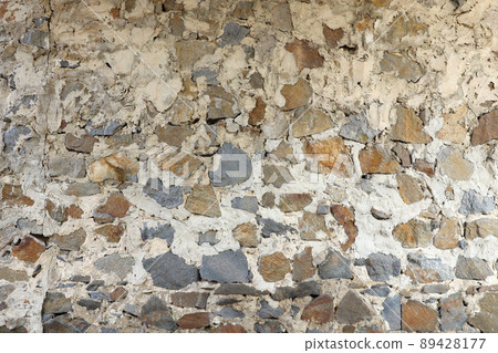 Texture of a stone wall with many big brown and grey stones armed with cement. Old castle stone wall texture background for medieval usage. Part of a stony building Texture of a stone wall with many big brown and grey stones armed with cement. Old castle stone wall texture background for medieval usage. Part of a stony building 89428177