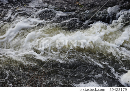 Waves of water of the river and the sea meet each other during high tide and low tide. Deep blue stormy sea water surface with white foam and waves pattern, background photo 89428179