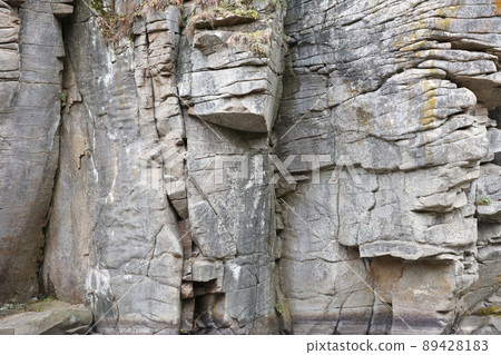 Light coarse natural rock stone background. Mining cliff rough front surface. Big limestone stack backdrop. Heavy grunge damaged granite block texture 89428183