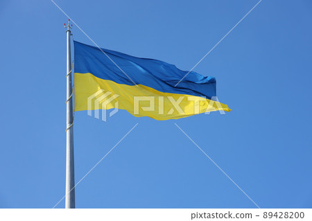 Ukrainian flag isolated on the blue sky with clipping path. Close up waving banner of Ukraine. Tall flag symbol of Ukraine, european country 89428200