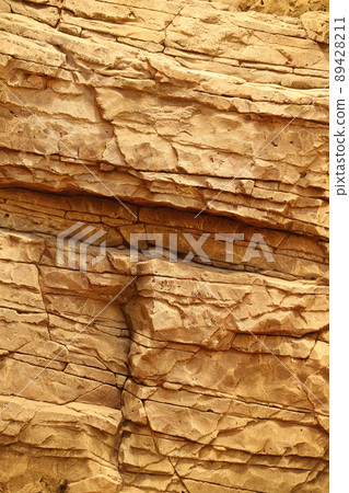 Light coarse natural rock stone background. Mining cliff rough front surface. Big limestone stack backdrop. Heavy grunge damaged granite block texture 89428211
