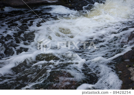 Waves of water of the river and the sea meet each other during high tide and low tide. Deep blue stormy sea water surface with white foam and waves pattern, background photo 89428254