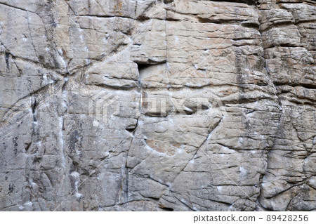 Light coarse natural rock stone background. Mining cliff rough front surface. Big limestone stack backdrop. Heavy grunge damaged granite block texture 89428256