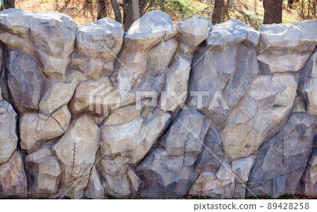 Texture of a stone wall with many big brown and grey stones armed with cement. Old castle stone wall texture background for medieval usage. Part of a stony building Texture of a stone wall with many big brown and grey stones armed with cement. Old castle stone wall texture background for medieval usage. Part of a stony building 89428258