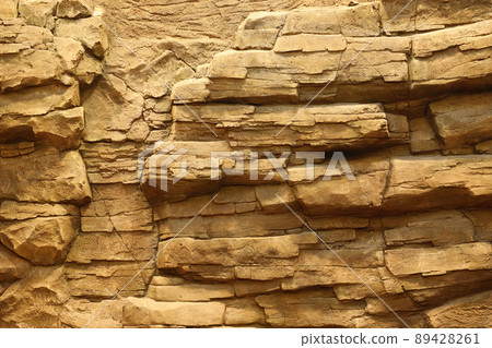 Light coarse natural rock stone background. Mining cliff rough front surface. Big limestone stack backdrop. Heavy grunge damaged granite block texture 89428261