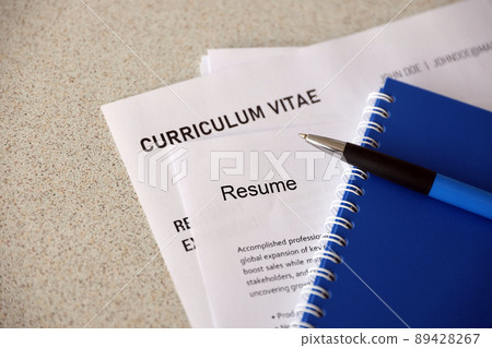 Top view of stack of office documents including resume and cv forms on the desk close to pen and notepad. Job seeking process. Hunting for workplace 89428267