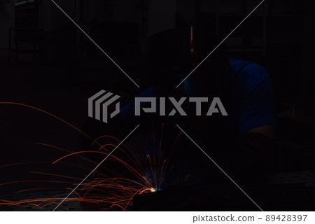 Professional Heavy Industry Welder Working Inside factory, Wears Helmet and Starts Welding. Selective Focus 89428397